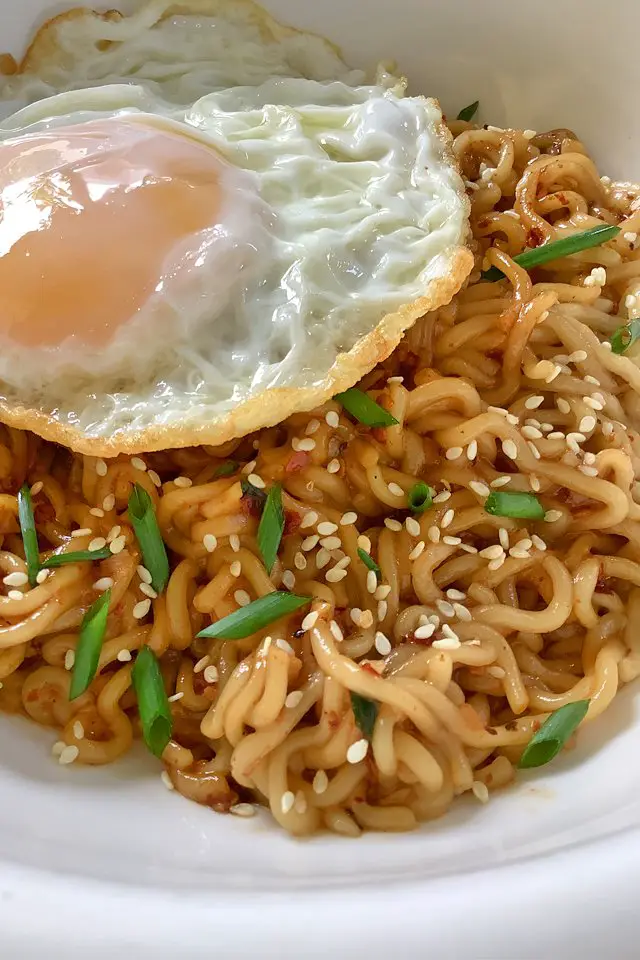 spicy garlic noodles with egg in a white plate, mom food blog